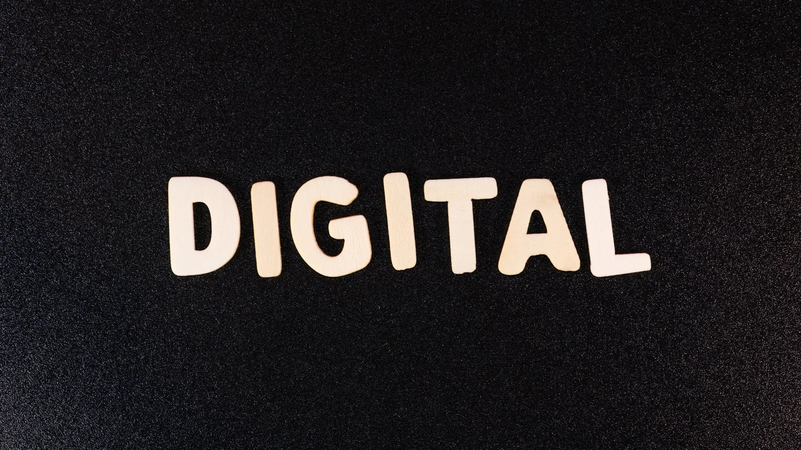 Mot “Digital” en lettres blanches sur fond noir texturé.