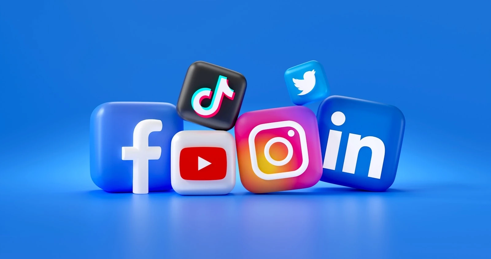 Icônes 3D des réseaux sociaux Facebook, Instagram, TikTok, YouTube, Twitter et LinkedIn sur fond bleu.